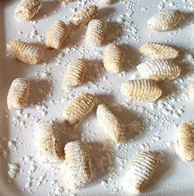 Plato de ñoquis de ricotta keto servidos con salsa ligera, textura esponjosa y dorada, acompañados de queso parmesano rallado. Receta baja en carbohidratos y sin gluten.
